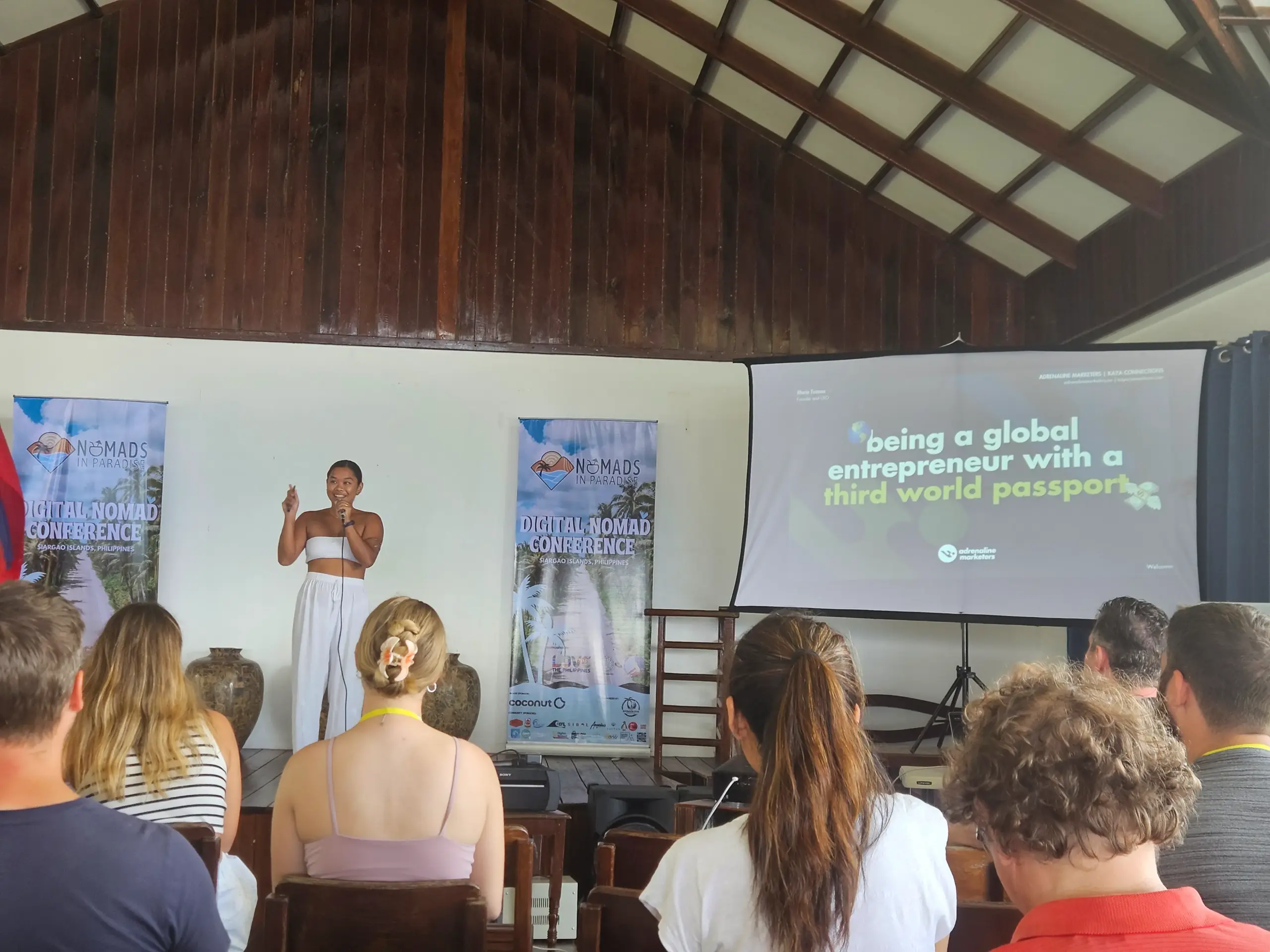 Filipino entrepreneur keynote on wooden stage at Nomads in Paradise with global entrepreneur slide