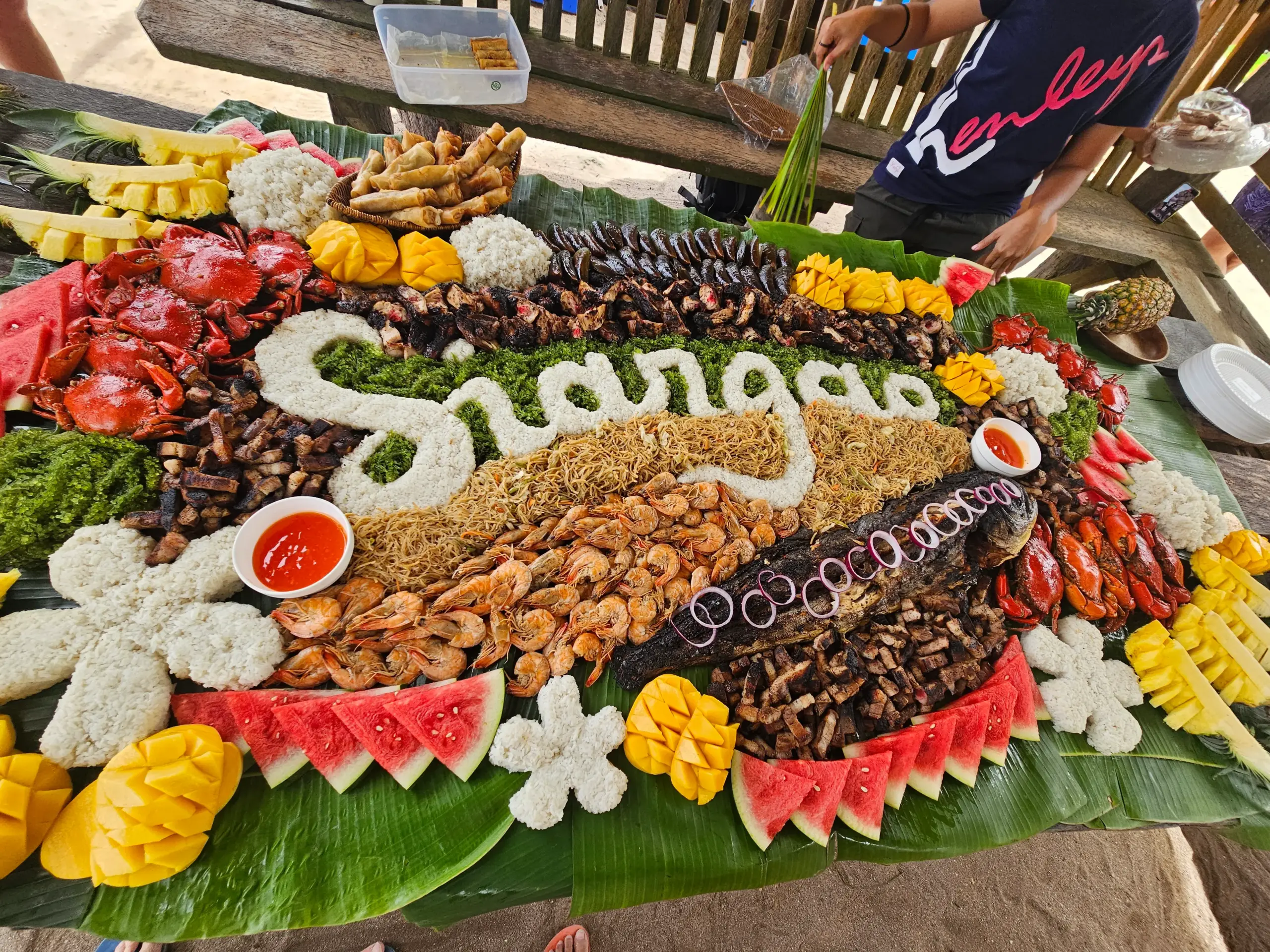 Siargao boodle fight feast spread with crabs prawns and grilled meats on banana leaves