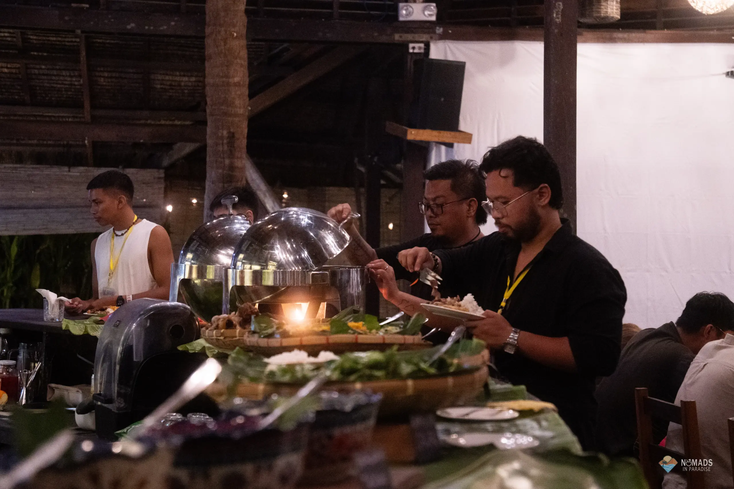 Attendees with yellow lanyards serving themselves at Filipino buffet during evening reception