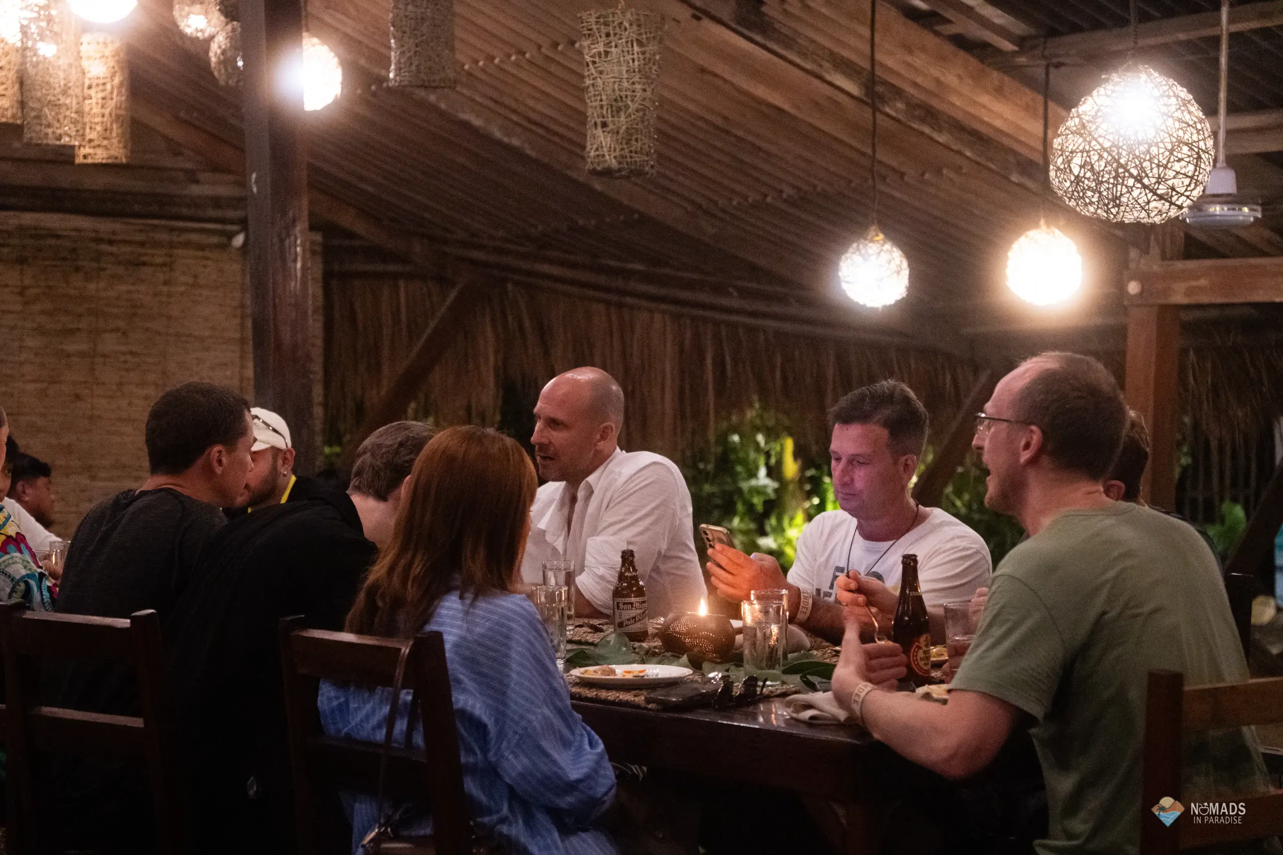 Nomads in Paradise attendees dining and networking under hanging woven lanterns