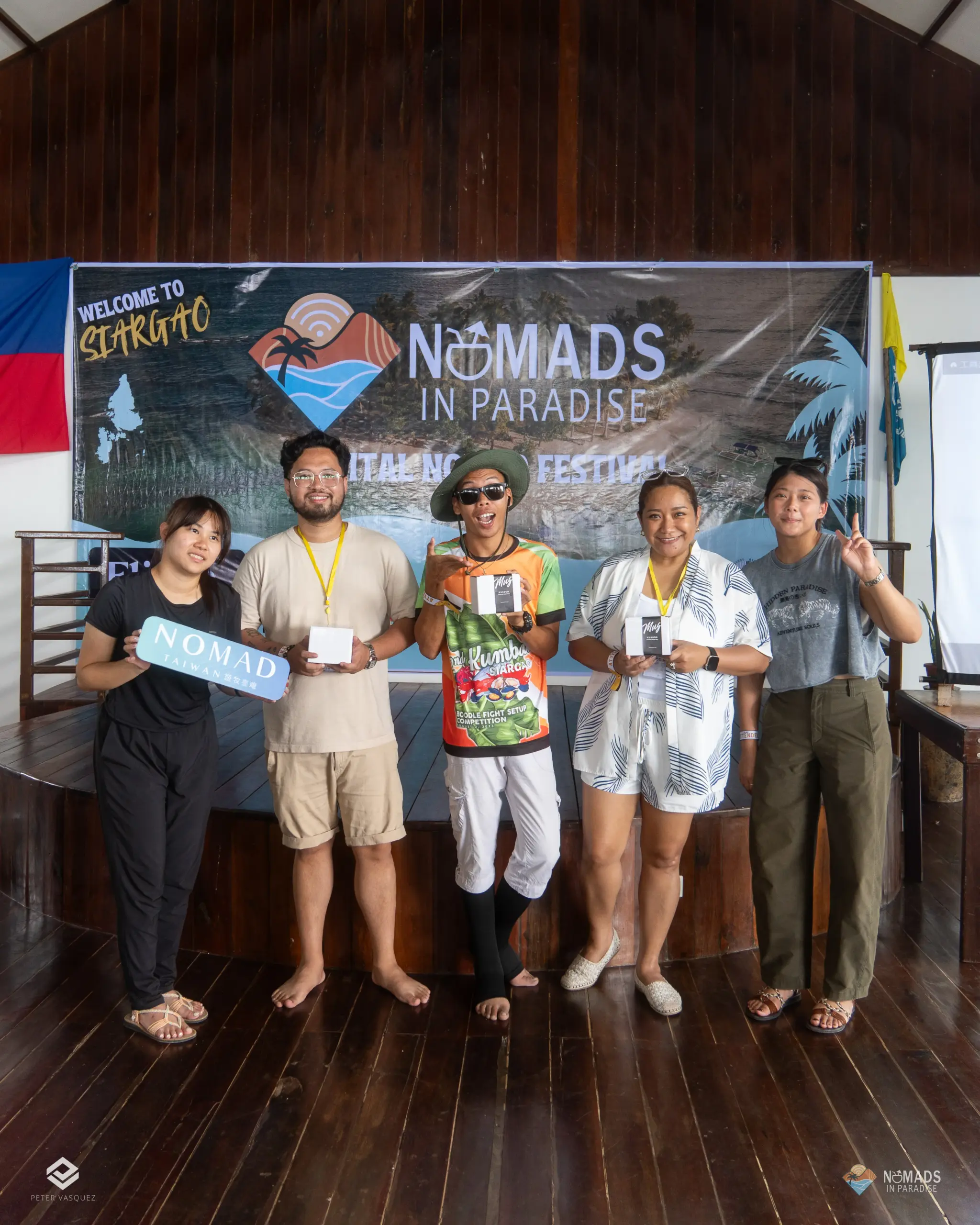 Five barefoot Nomads in Paradise attendees posing on festival stage with gift boxes