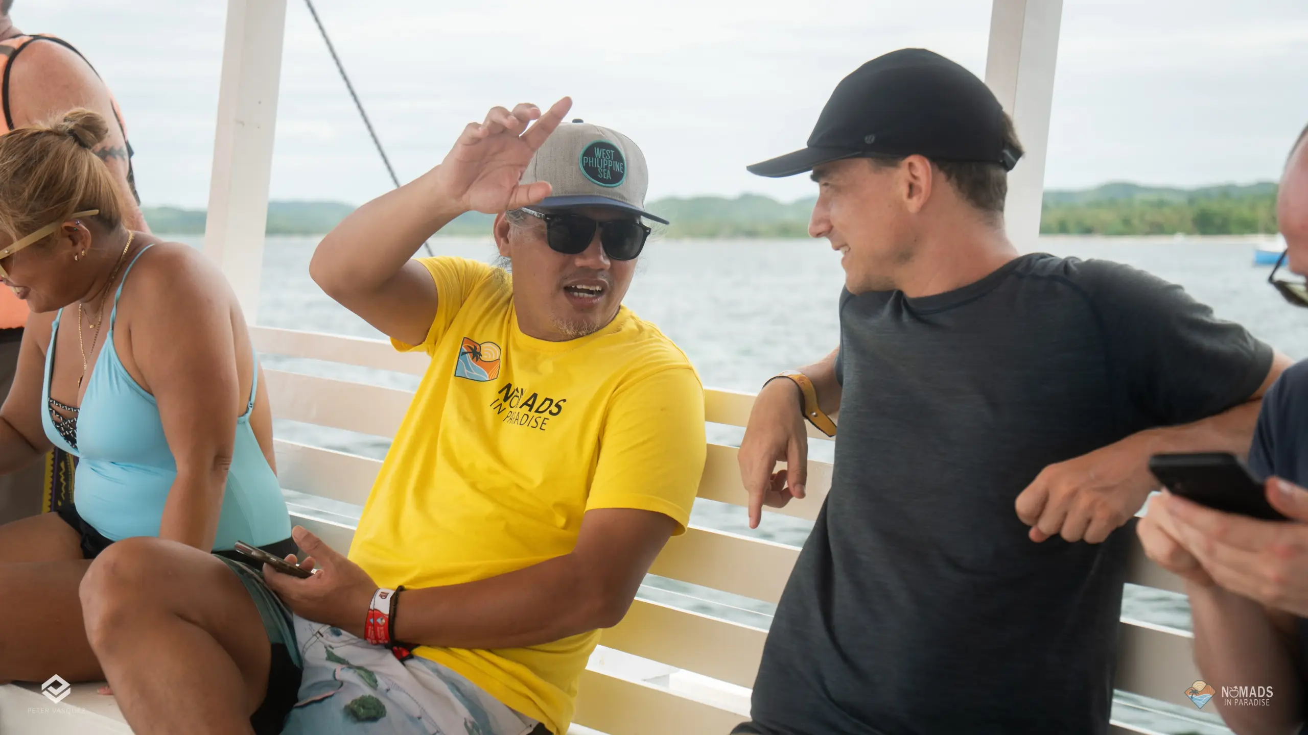 Nomads in Paradise attendee in yellow shirt networking on boat excursion with coastal hills