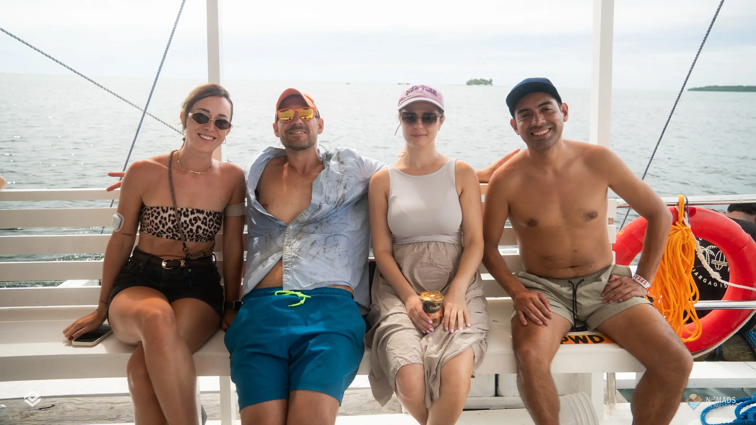 Four Nomads in Paradise attendees smiling on boat bench during island excursion