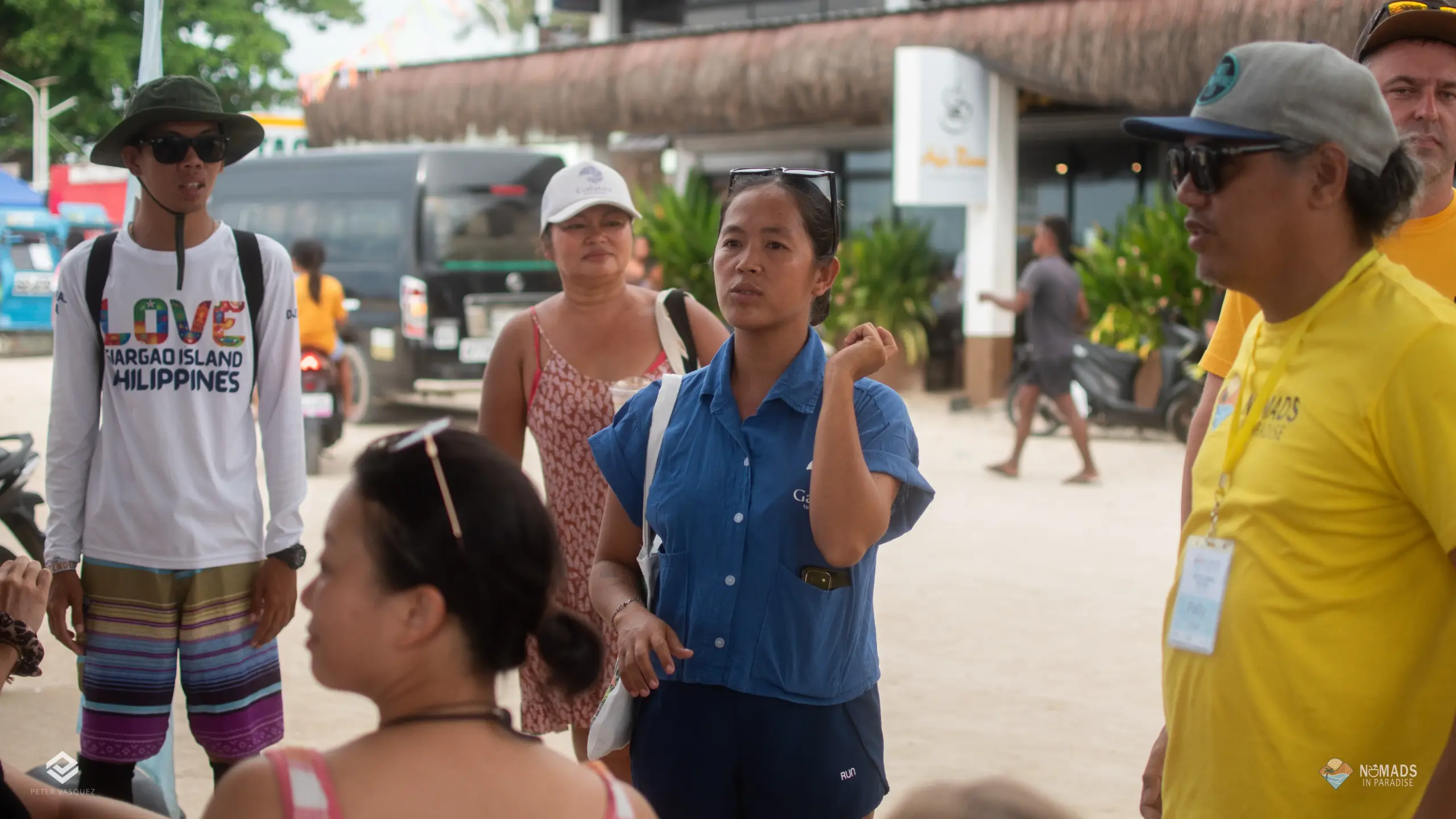 Nomads in Paradise attendees gathering outdoors near thatched buildings and palm trees in Siargao