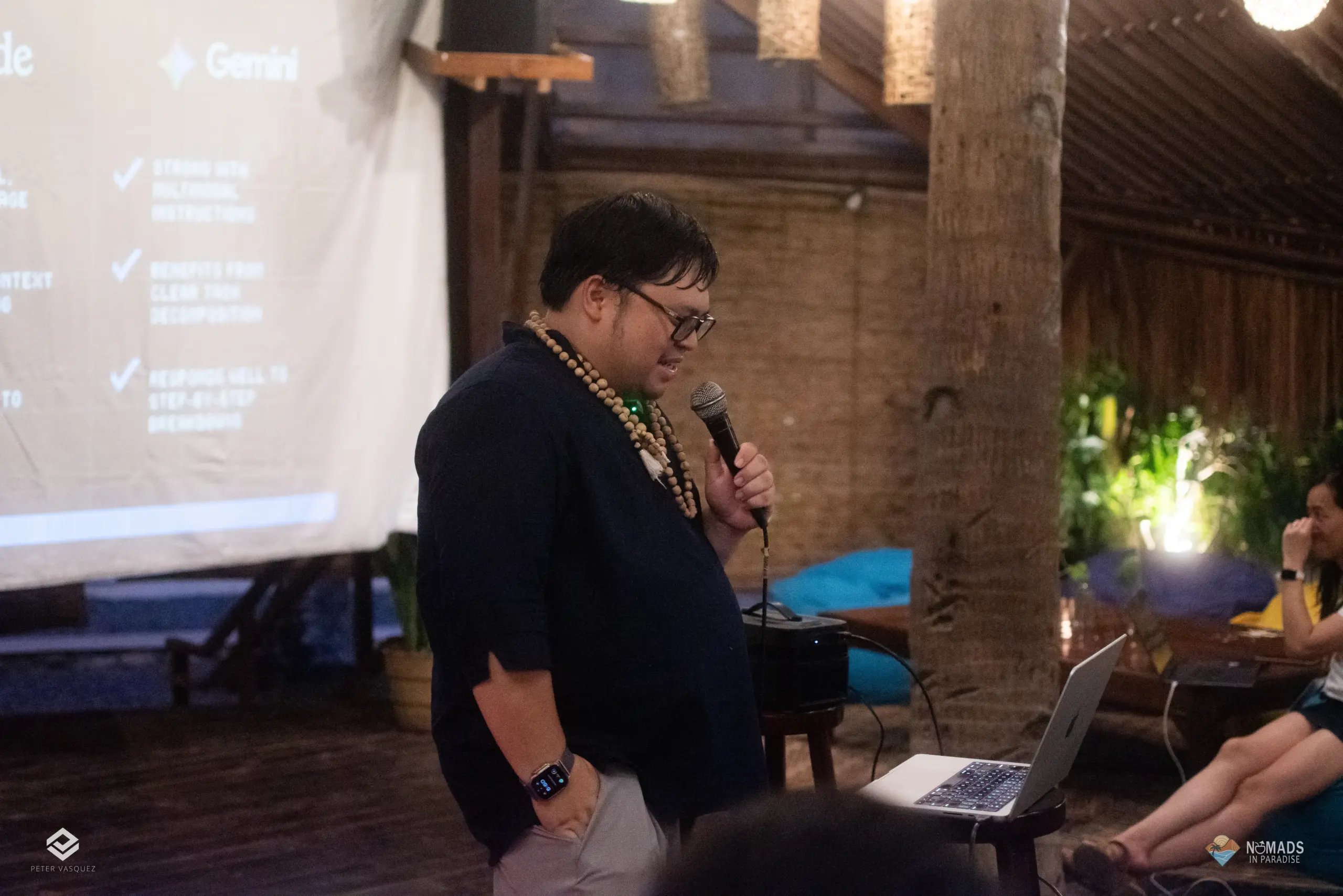 Speaker delivering presentation beside laptop at outdoor Nomads in Paradise evening session