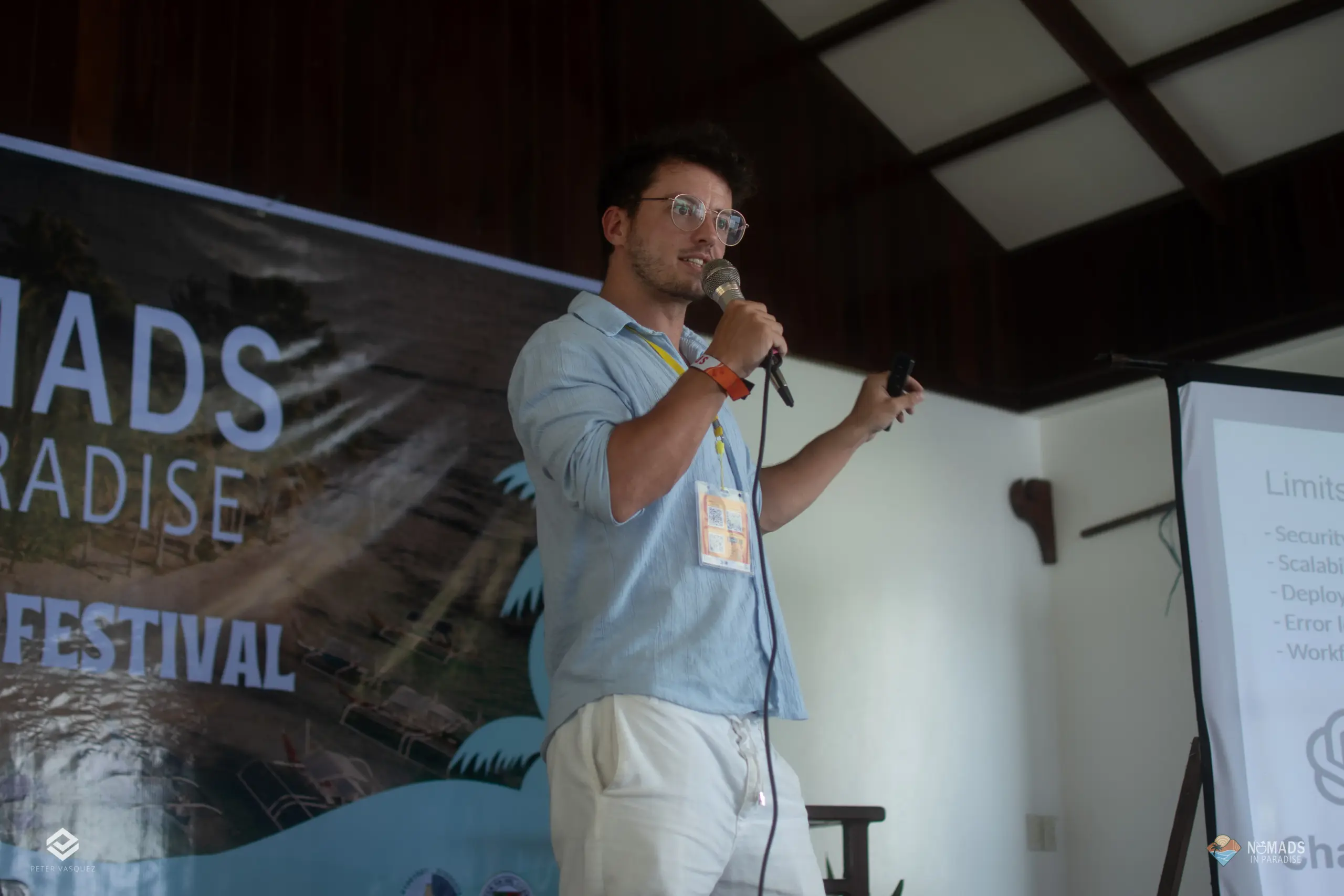 Speaker with microphone and clicker on Nomads in Paradise festival stage — practitioner keynote