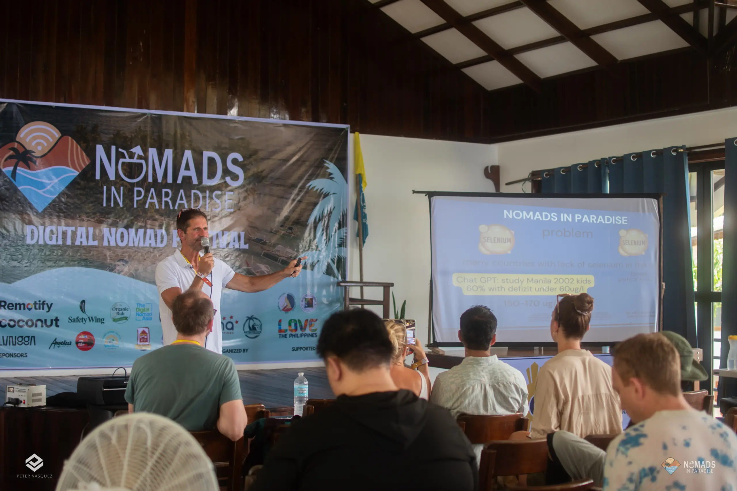 Speaker pointing to presentation slide during Nomads in Paradise conference talk